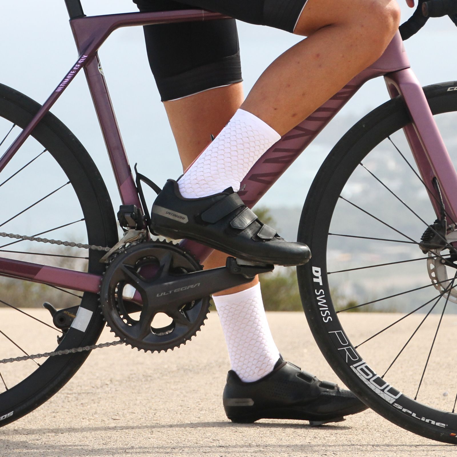 Pies en una bicicleta llevando calcetines ciclismo blancos